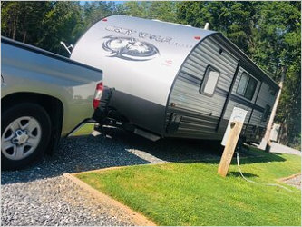 RV trailer and truck hooked up at a camp site